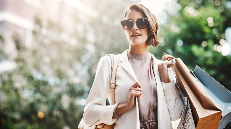 Well-dressed woman with sunglasses holding shopping bags
