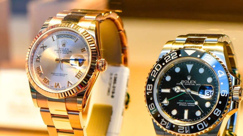 Different types of Rolex watches on display in a store window.