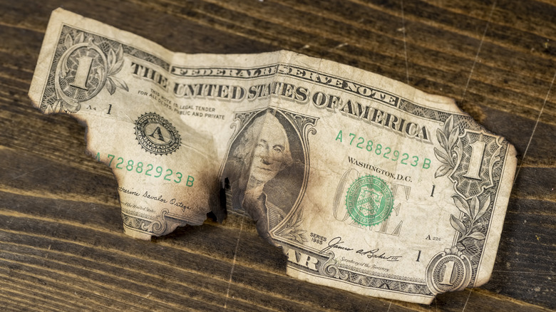 U.S. dollar bill that has burn marks on it